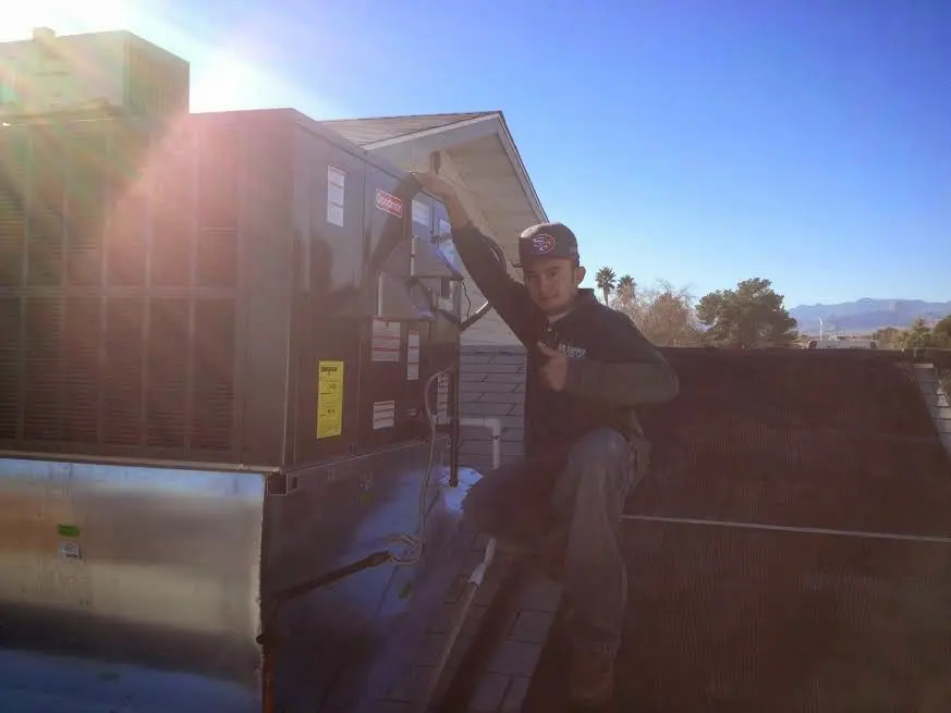 HVAC technician performing AC Tune-Up on a rooftop unit in Crossville